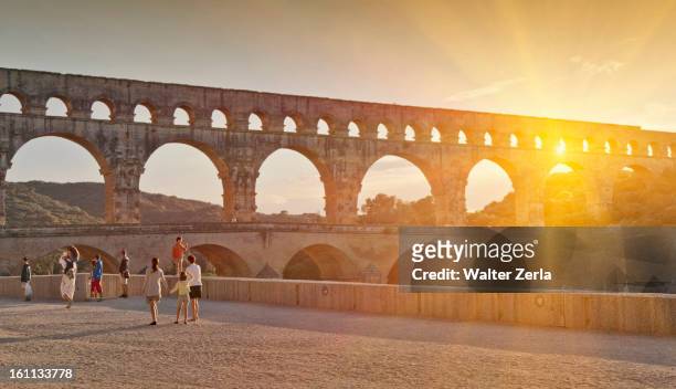 people sightseeing near aqueduct - pont du gard aqueduct ストックフォトと画像