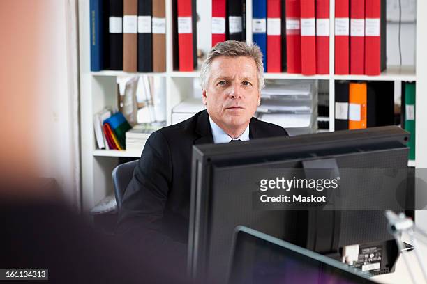 businessman sitting in front of computer - mann vor pc stock-fotos und bilder