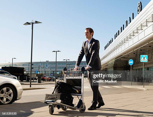 man with trolley at parking lot - luggage trolley stock pictures, royalty-free photos & images