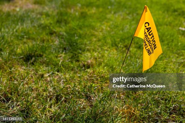 yellow utility warning flag in residential yard - generic safety sign stock pictures, royalty-free photos & images