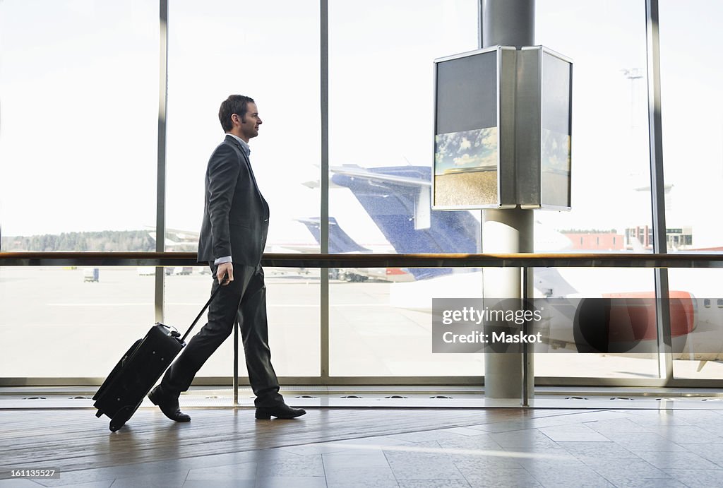 Businessman pulling suitcase
