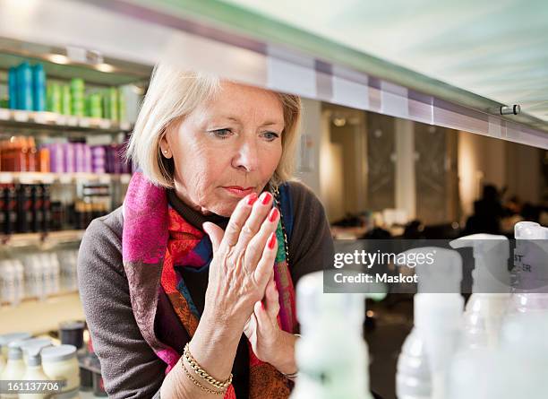 woman thinking about buying - cosmetic testing store stock pictures, royalty-free photos & images