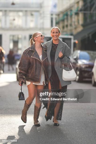 Guest wears white latte vintage sunglasses, a dark brown faded leather zipper oversized jacket, a white latte slit / split short dress, a black shiny...