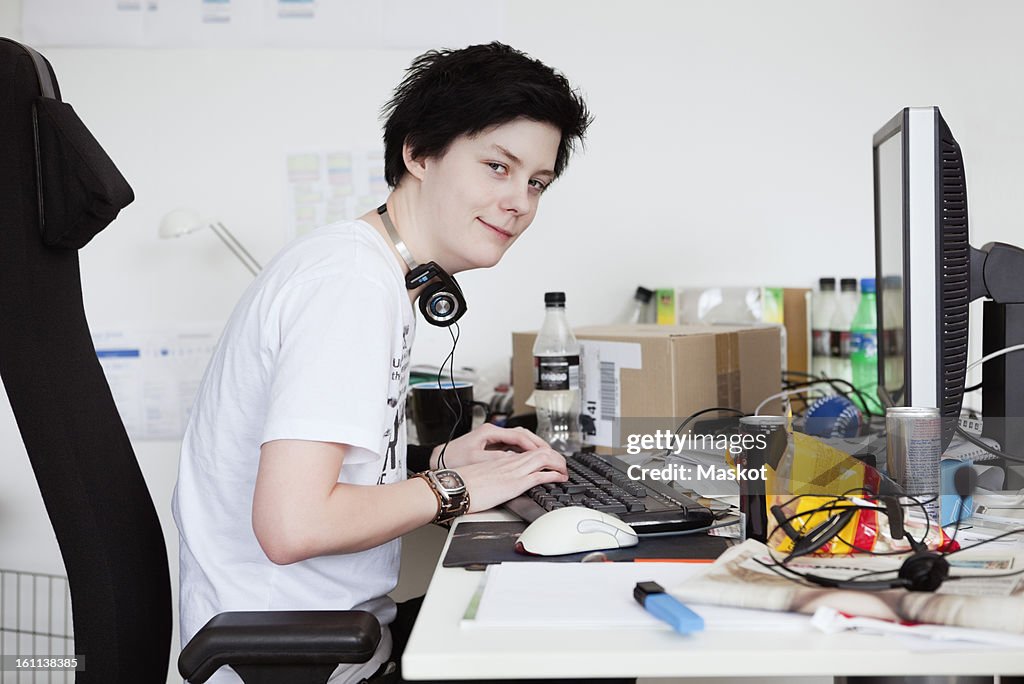Young woman sitting by computer hacking codes
