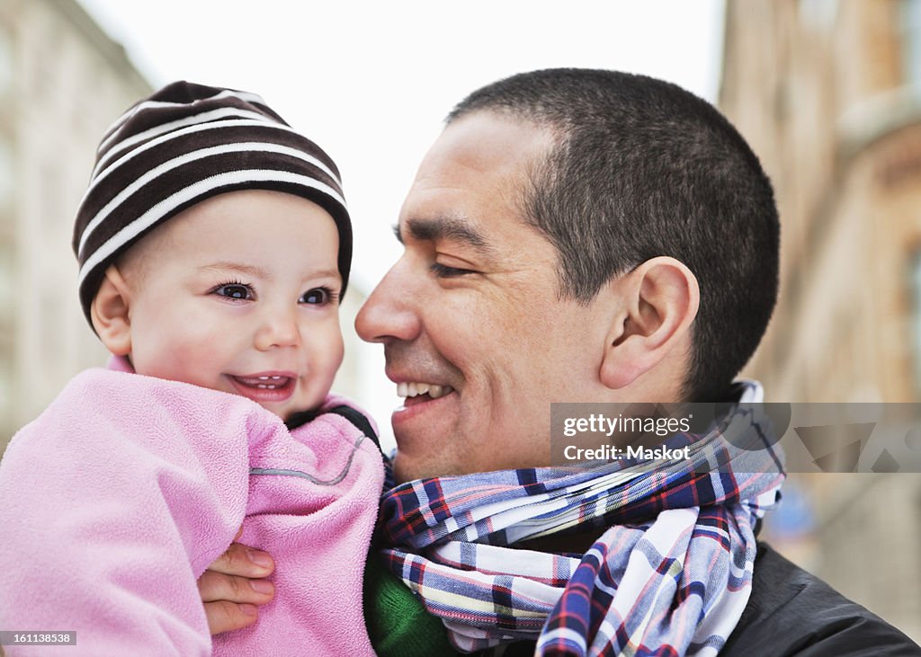 Close-up of father and daughter (0-11 months) smiling