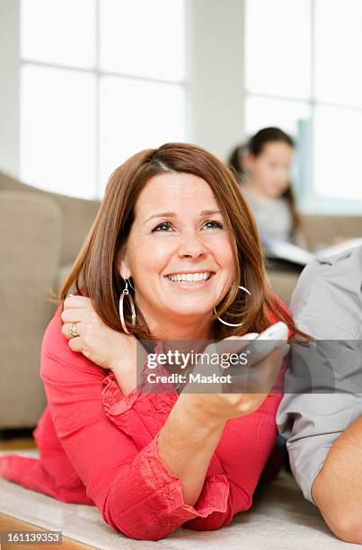 mother watching tv - changing channels stock pictures, royalty-free photos & images