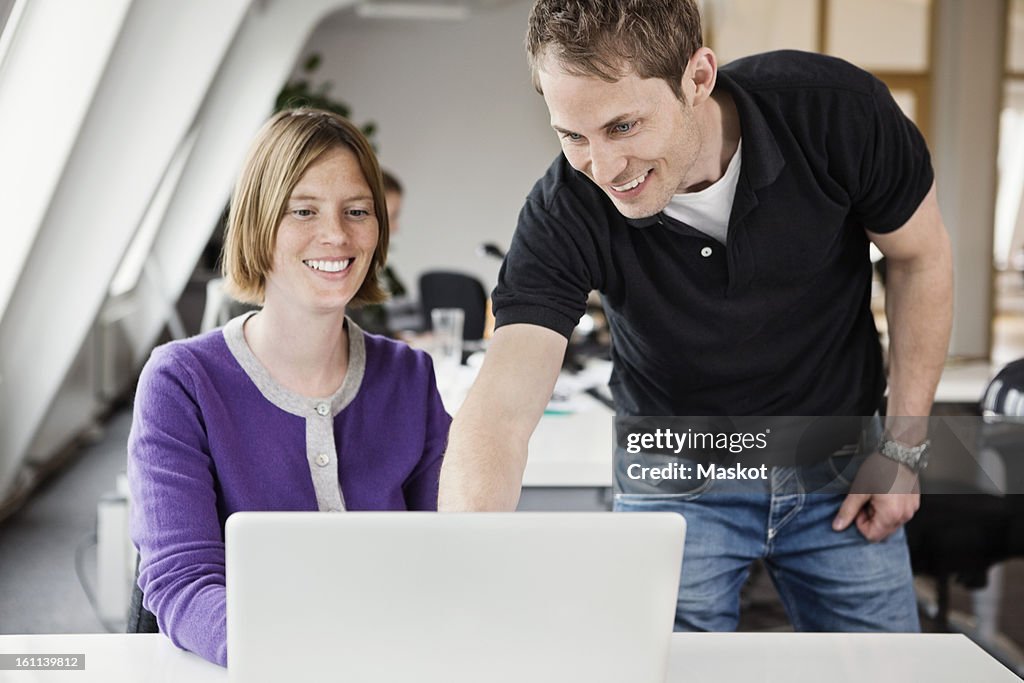 Colleagues working on project together on laptop
