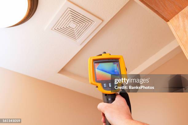 infrared thermal imaging camera pointing to attic access - thermal image stock pictures, royalty-free photos & images