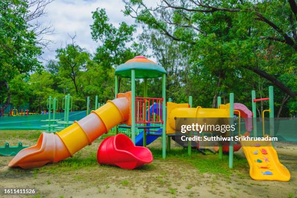 close-up of slide - play eauipment in playground against trees in park - speeltuin stockfoto's en -beelden