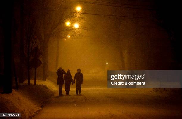 Pedestrians stand in the snow on Cedar Street during Winter Storm Nemo in Somerville, Massachusetts, U.S., on Friday, Feb. 8, 2013. More than two...