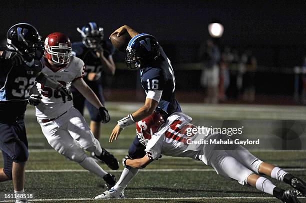 Brock Berglund dodges Regis' Drake Thenell while running with the ball for a down at the Valor Christian High School-Regis High School football game...