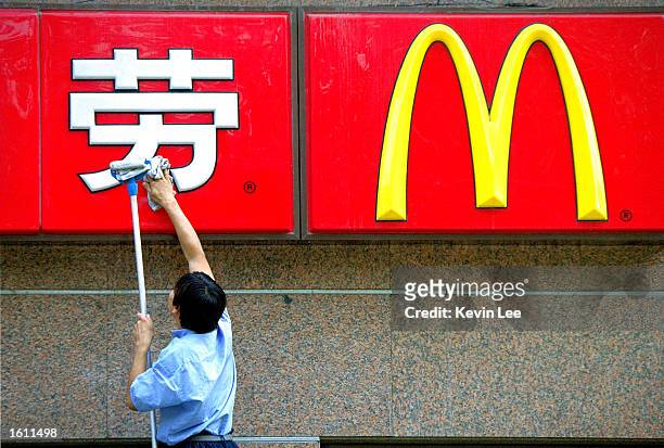 Chinese worker cleans the sign in front of a McDonald''s restaurant in August 29, 2001 Beijing. China''s expected entry into the world trade...