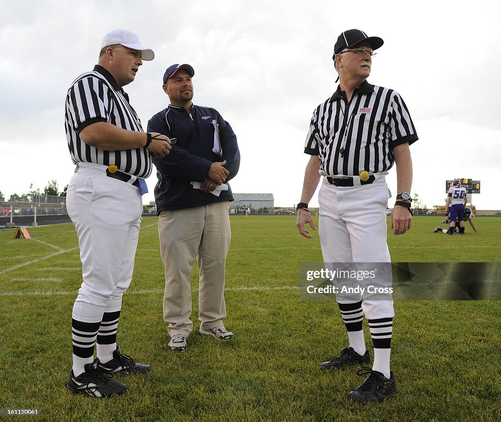 AKRON, CO--SEPTEMBER 10TH 2010--Akron High School head football coach, Brian Christensen, center, talks with referee, Mike Billadeau, left, and official, Jim Short, before the game against Rye at Akron Friday evening. Andy Cross, The Denver Post
