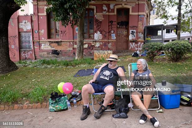 Couple looks at soapbox cart riders racing downhill during the 10th edition of the Rolima do Abacate event during the Virada Cultural festival in...