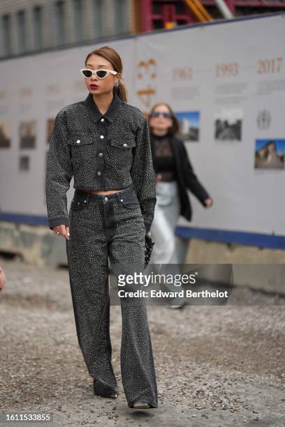 Guest wears white latte vintage sunglasses, black and crystals earrings, a dark gray denim with embroidered crystals buttoned jacket, matching dark...