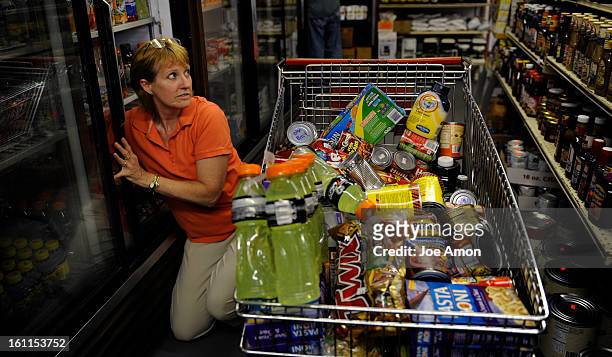 Jo Palumbo stocks the shelves after the prices have been marked down by her husband Martin at the Friday Store, Inc. In Arvada. The store is only...