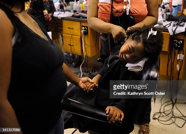 Damonjaznae Armstrong gets a special hairstyle from stylist Nora Fruge whil mom Darlisa Navarro stand by to hold her daughter's hand. This is the...
