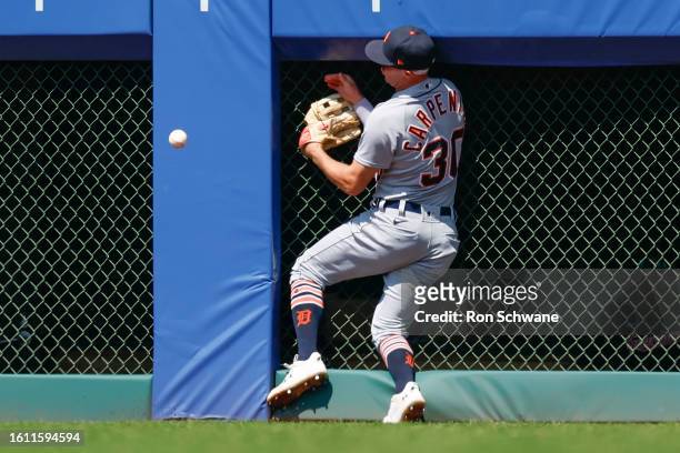 Kerry Carpenter of the Detroit Tigers crashes to the wall as he tries to catch a ball on a double hit by Steven Kwan of the Cleveland Guardians...