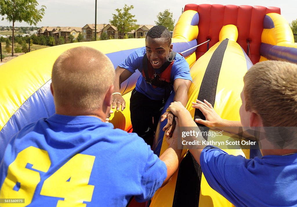 The Blakeman family celebrates the third annual 'Concert for Kyle' at Civic Green Park in Highlands Ranch, themed "Remember, Celebrate, Educate." Former football teammates of Kyle's hold the hand of Justin Travis, 17, in the sling shot game. The benefit c