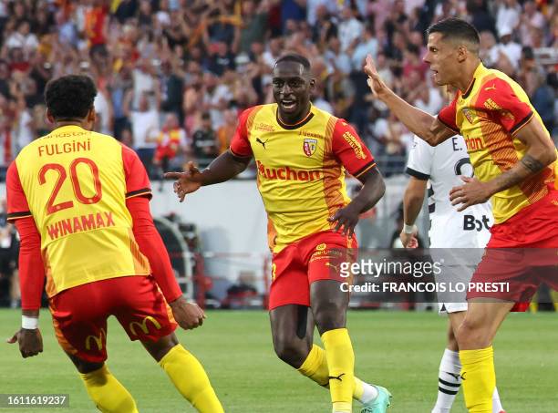 Lens' Colombian defender Deiver Machado is congratulated by teammates after he scored a first goal for his team during the French L1 football match...