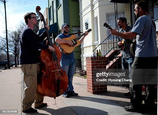From left, the members of "Rough Sawn Timber" Jason Siegel, Mike Moran, Tim DiBerardino and Nick Mouw enjoy the music and sunshine at the corner of...