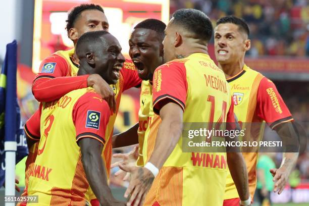 Lens' Colombian defender Deiver Machado is congratulated by teammates after he scored a first goal for his team during the French L1 football match...