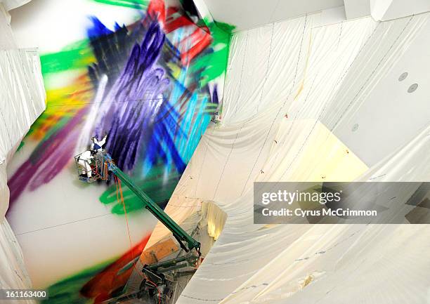 German artist Katharina Grosse has begun work on her four-story spray painting in the atrium of the Hamilton Building at the Denver Art Museum on...