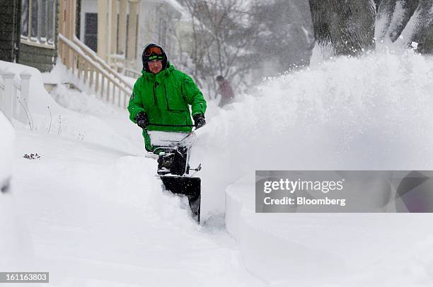 Resident Ted Miller clears snow from the sidewalk outside his home after Winter Storm Nemo in Somerville, Massachusetts, U.S., on Saturday, Feb. 9,...