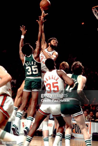 American basketball player Kareem Abdul-jabbar , of the Milwaukee Bucks, tips the ball towards the basket in a game against the Boston Celtics,...