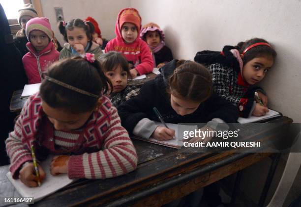 Syrian children attend a class at a school in the Kadi Askar area in the Syria's northern city of Aleppo on February 9, 2013. President Bashar...