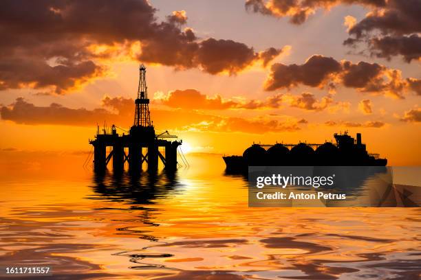 oil platform at sea and lng carrier at sunset. world oil and gas industry - gas-natural-licuado fotograf