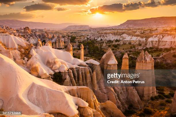 love valley at sunrise in cappadocia, turkey - cave fire stock pictures, royalty-free photos & images