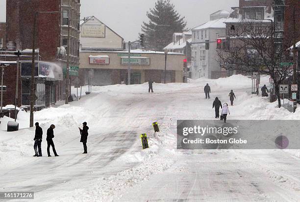 People begin to dig out from the big blizzard. People walk along Dorchester Street in South Boston.