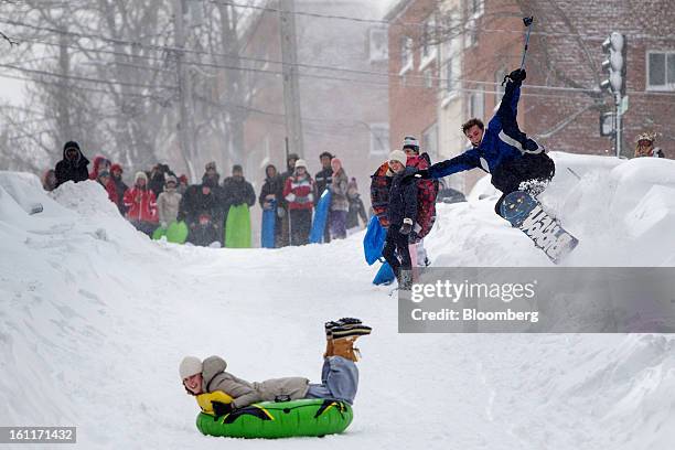 Snowboarder catches air as a resident sleds down the street after Winter Storm Nemo in Boston, Massachusetts, U.S., on Saturday, Feb. 9, 2013. More...