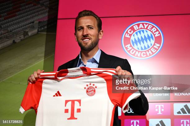 Harry Kane of FC Bayern München poses for a photograph whilst holding a FC Bayern München shirt after speaking to the media during an official press...