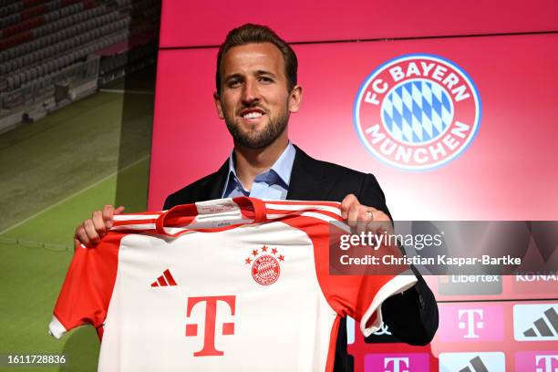 Harry Kane of FC Bayern München poses for a photograph whilst holding a FC Bayern München shirt after speaking to the media during an official press...