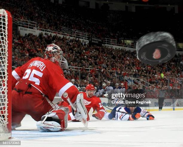 Jimmy Howard of the Detroit Red Wings makes a blocker save deflecting the puck into the corner during a NHL game against the Edmonton Oilers at Joe...