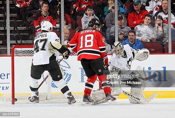 Marc-Andre Fleury of the Pittsburgh Penguins surrenders a third period goal against Bobby Butler of the New Jersey Devils as Simon Despres defends...