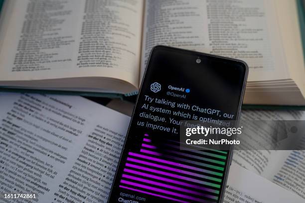 Open Ai page displayed on a smart phone with a dictionary book, seen in this photo illustration. On 20August 2023 in Brussels, Belgium.