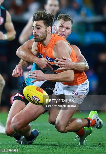 Stephen Coniglio of the Giants tackled by Dan Houston of Port Adelaide during the round 22 AFL match between Port Adelaide Power and Greater Western...