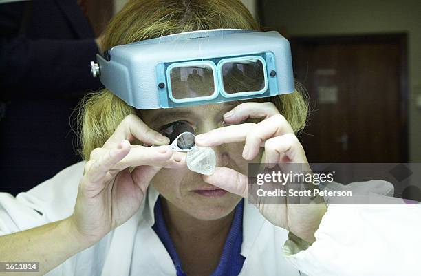 Sorter inspects a 143-carat Russian diamond in the sorting rooms of the United Selling Organization, a branch of Russia''s state Alrosa diamond...