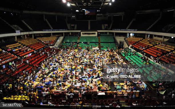 Residents affected by the floods brought about by tropical storm ketsana rest inside a gymnasium serving as an evacuation center in Pasig, suburban...