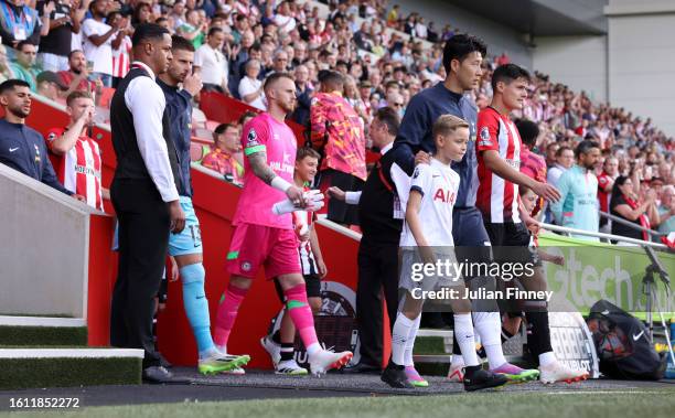 Heung-Min Son of Tottenham Hotspur and Christian Noergaard of Brentford lead their team out onto the pitch prior to the Premier League match between...