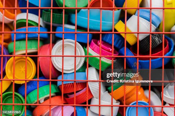 plastic bottle caps background. cap material is recyclable. remove lids from plastic bottles before recycling them. recycling collection and processing plastic bottle caps - polypropylene stock pictures, royalty-free photos & images