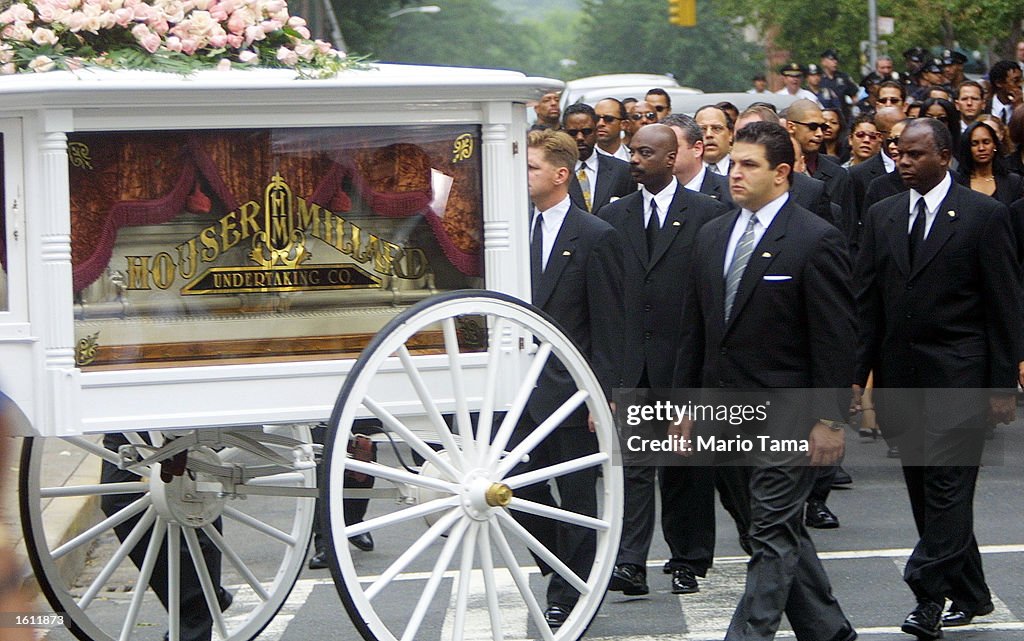 A horse drawn carriage carries R&B singer Aaliyah''s coffin towards