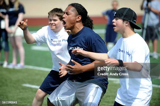 Valor Christian High School graduate, CSU freshman, George Talanoa, center, leads a chant during a football camp participants with Down Syndrome, at...