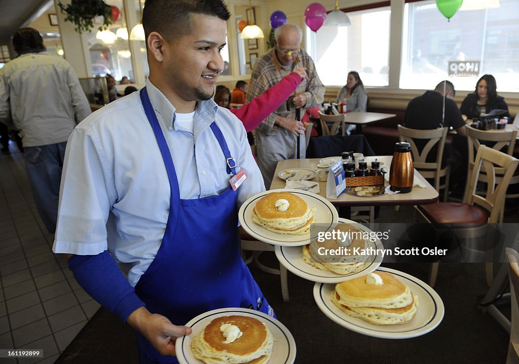 Server Ruben Avalos performs a balancing act with several plates of the free pancakes. The International House of Pancakes hosts a National Pancake Day at its restaurants across the country on Tuesday, Mar.1, 2011. By serving each patron a free short stac