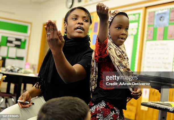 JaMese Stepanek reads poetry with first grade student Citi Hejab during class at McMeen Elementary School on Thursday, April 21, 2011. AAron...
