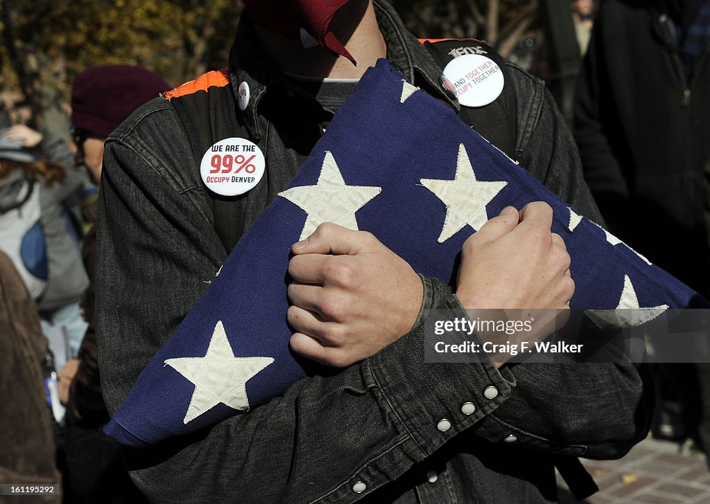 Matt Dolloff carries an American flag during the Occupy Denver Protest in Denver, CO, Saturday, November 12, 2011. He says he carries the flag because corporations have killed America. Later, Denver police forced protestors out of Civic Center park early