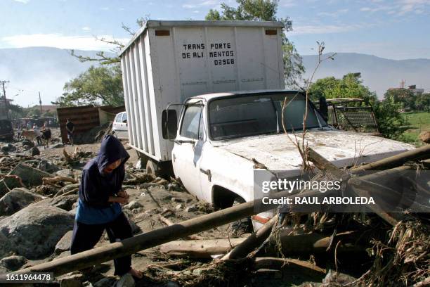 Boy walks past a stranded truck in Medellin, department of Antioquia, Colombia, on June 11, 2008 after heavy storms hit the region. Twenty houses...